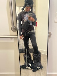 a person taking a selfie in a mirror wearing furry boots