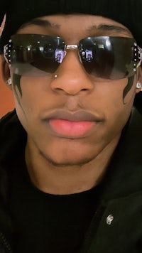 a young man wearing sunglasses and a beanie